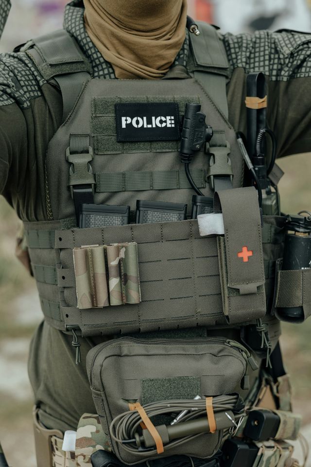 Membre des forces de l'ordre en gilet tactique avec écusson de police, chargeurs et équipement