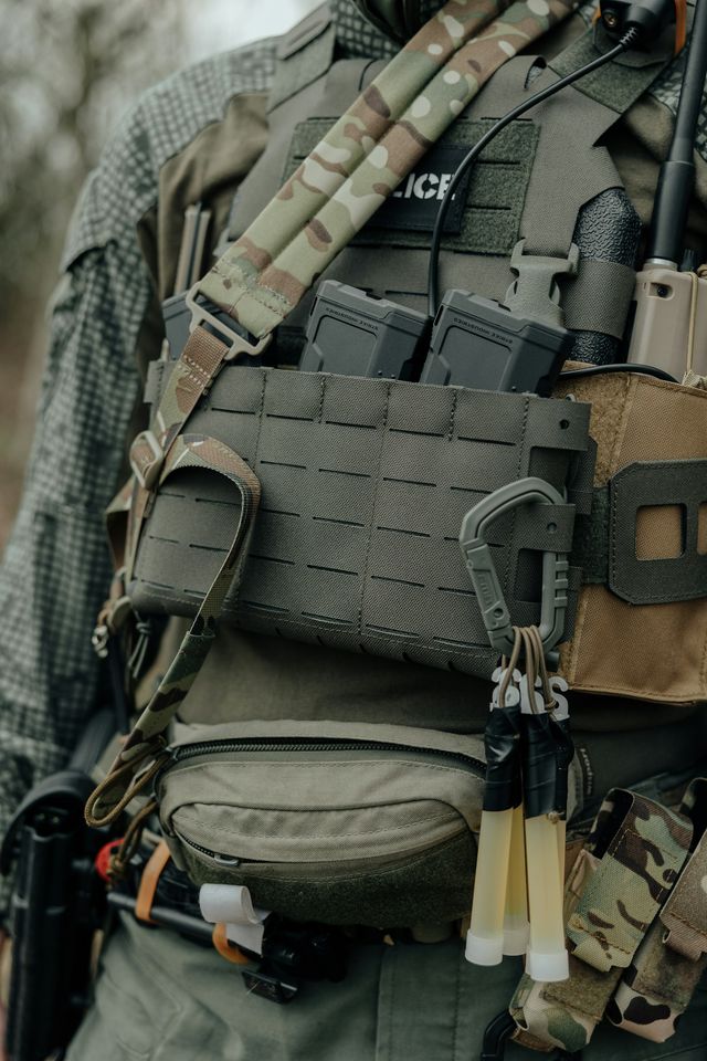 Joueur d'airsoft en gilet tactique équipé d'une radio et de porte-chargeurs