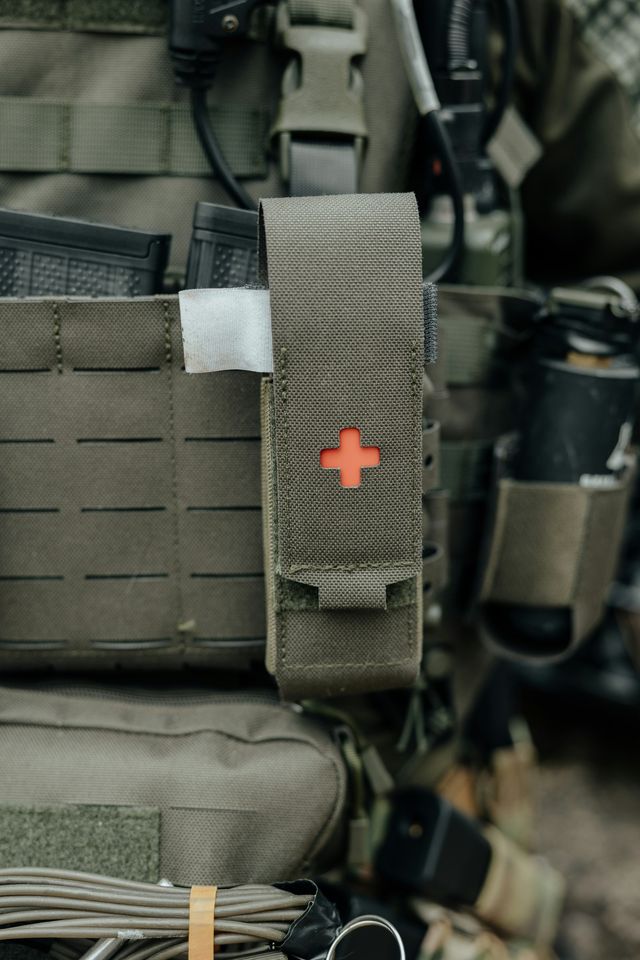Gilet tactique d'airsoft avec pochette médicale, équipement posé à plat