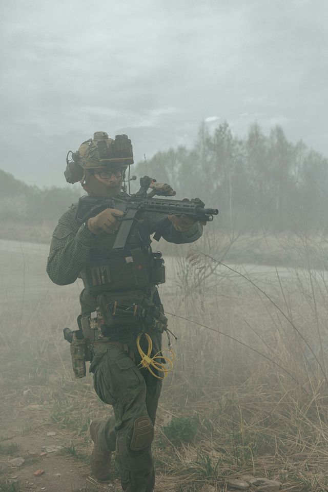 Joueur d'airsoft équipé d'une protection faciale intégrale en extérieur brumeux