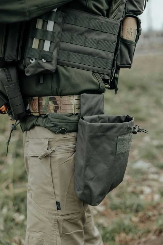 Joueur d'airsoft en tenue tactique avec dump pouch et équipement de progression
