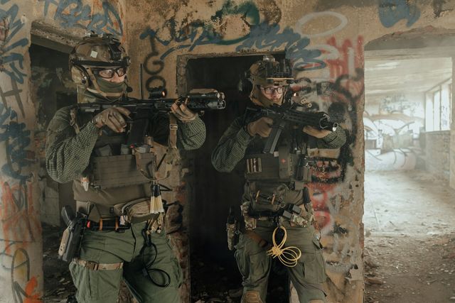 Deux joueurs d'airsoft avec leurs répliques dans un bâtiment désaffecté