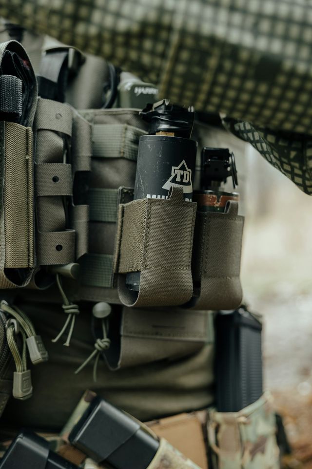 Gilet tactique et accessoires airsoft disposés à plat, prêts à être rangés