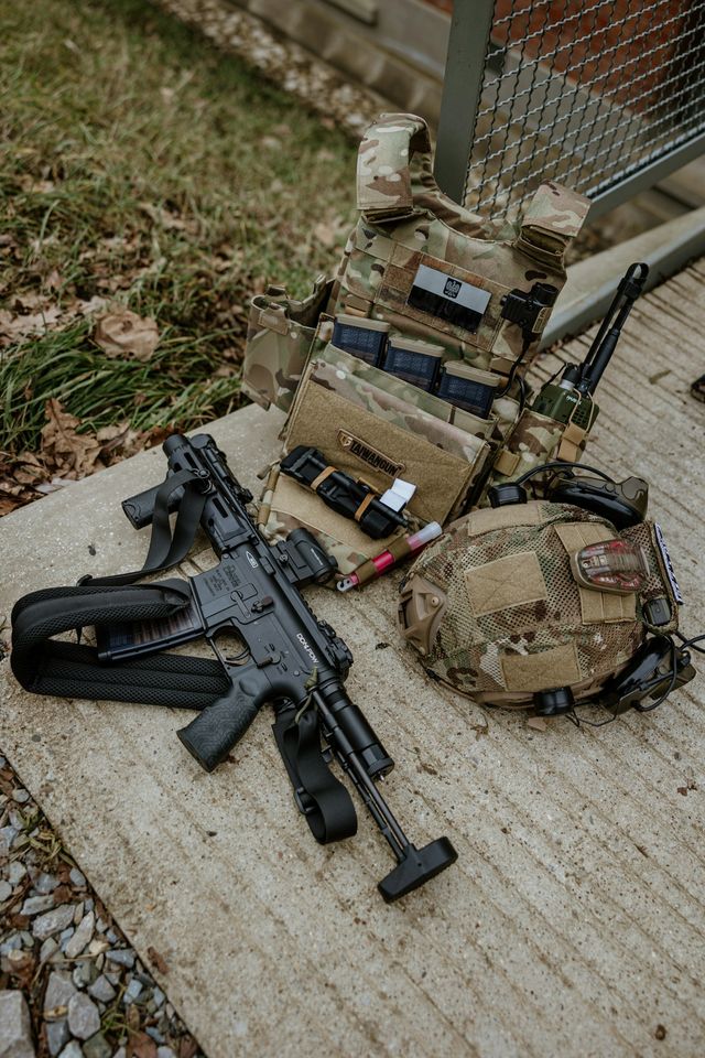Loadout airsoft complet avec réplique, chargeurs et équipement tactique disposés pour préparer une partie